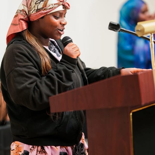 Woman speaking at a podium with a microphone