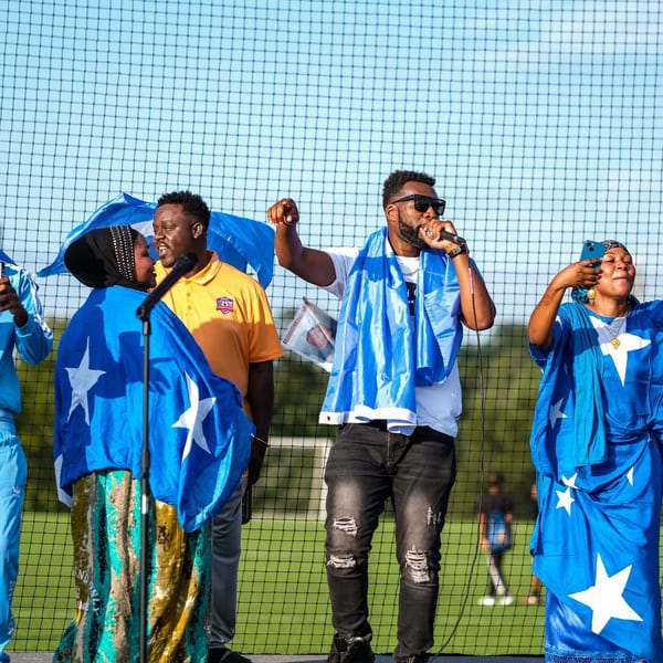 Performers wearing blue star outfits on a soccer field