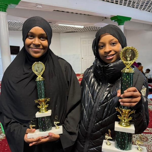 Two girls holding trophy awards indoors