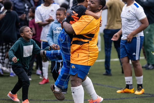 Man lifting a child during a community sports event
