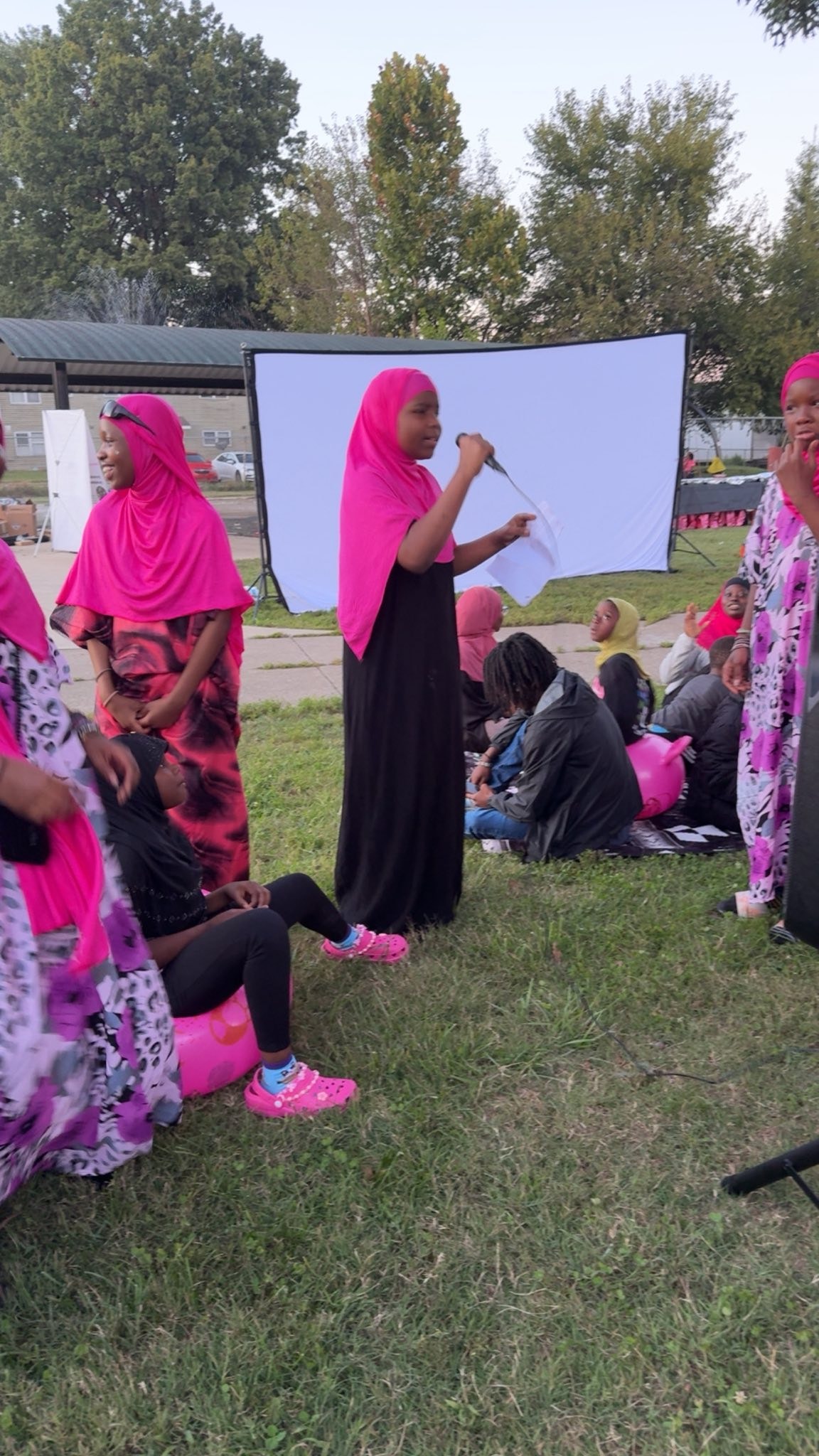 Woman speaking at an outdoor community gathering