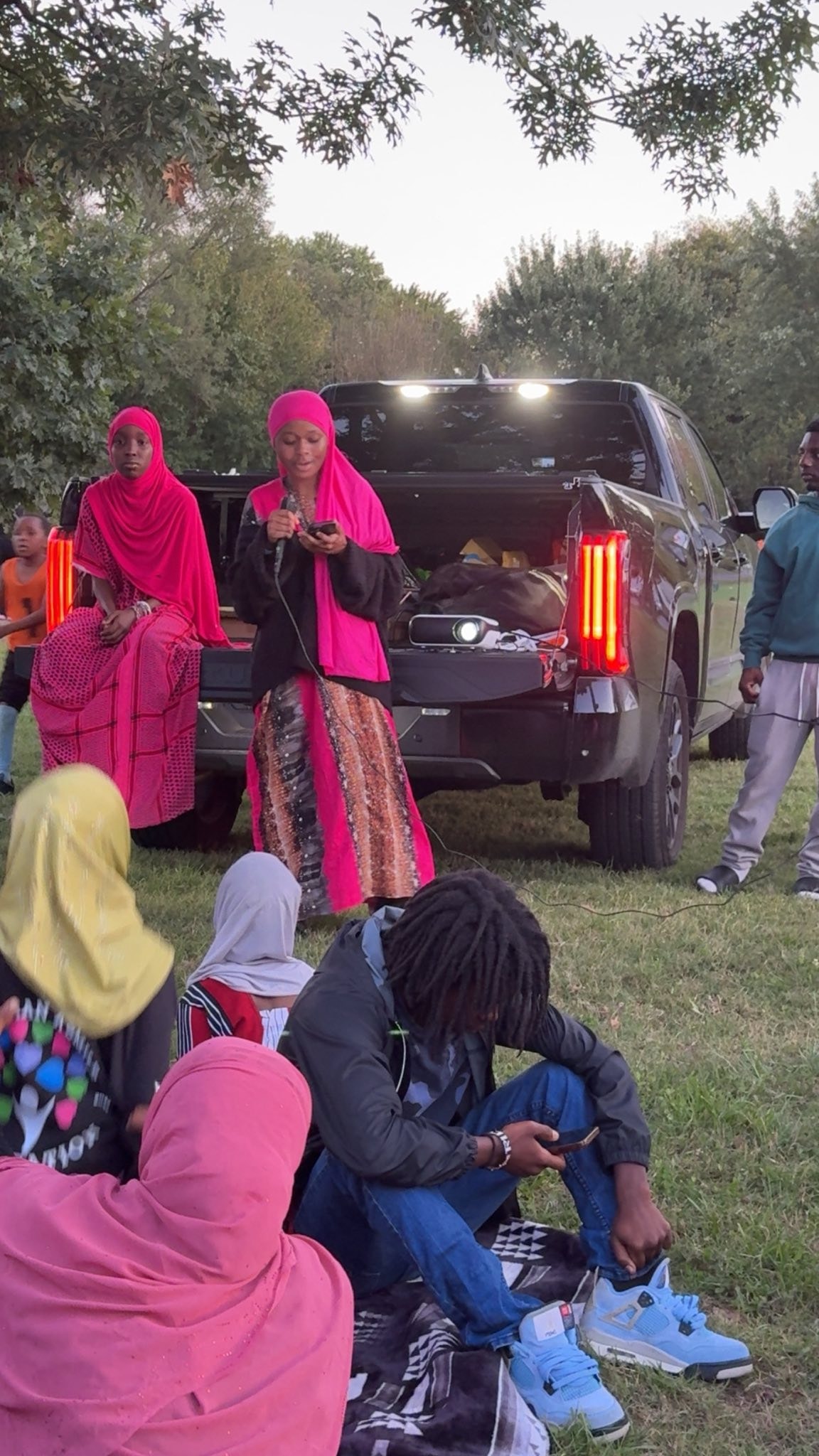 Women in pink hijabs gathering outdoors