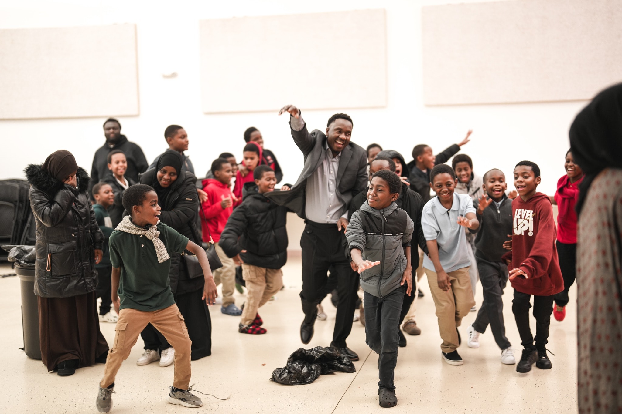 Man leading children in an indoor celebration