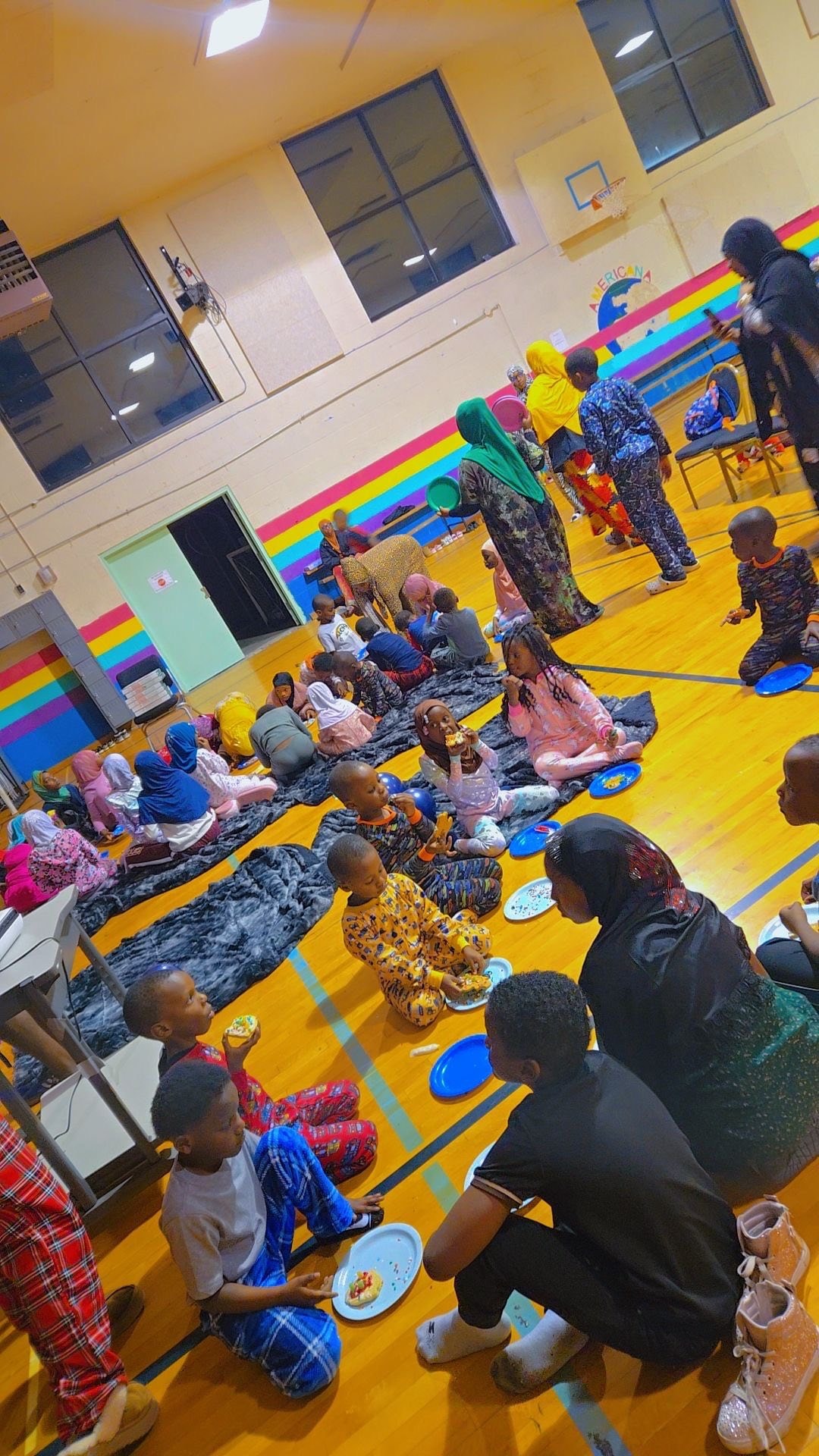 Children and families gathering in a school gymnasium