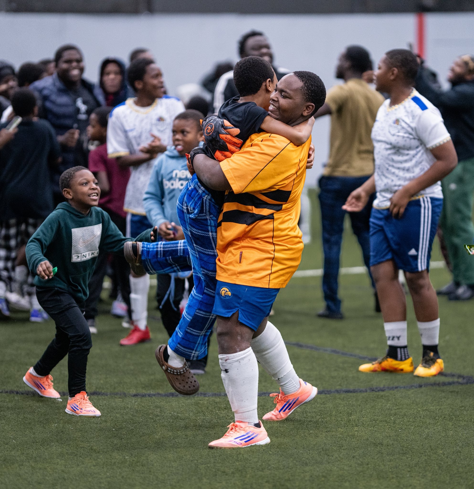 Man lifting a child at a youth sports event