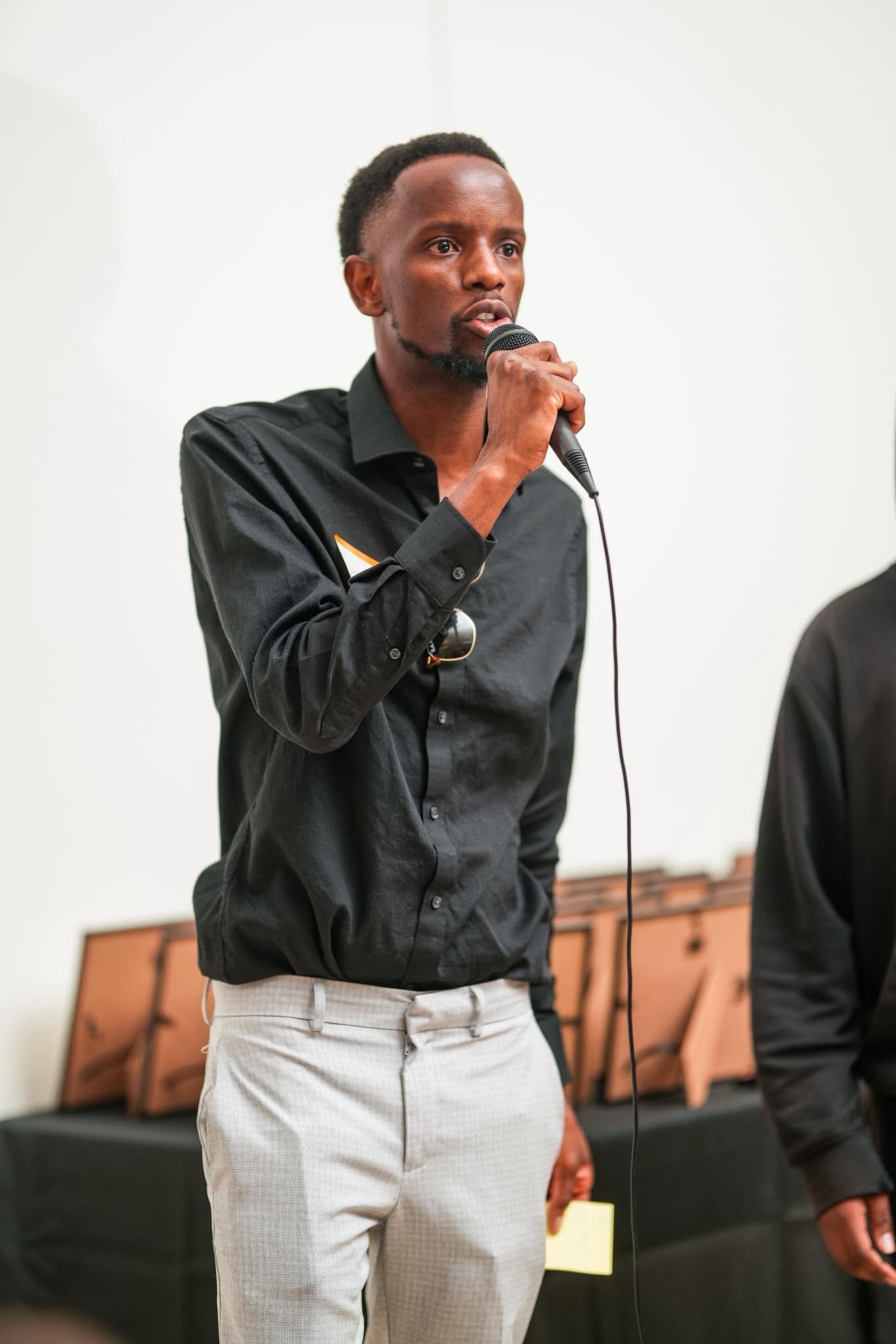 Man speaking into a microphone at an event