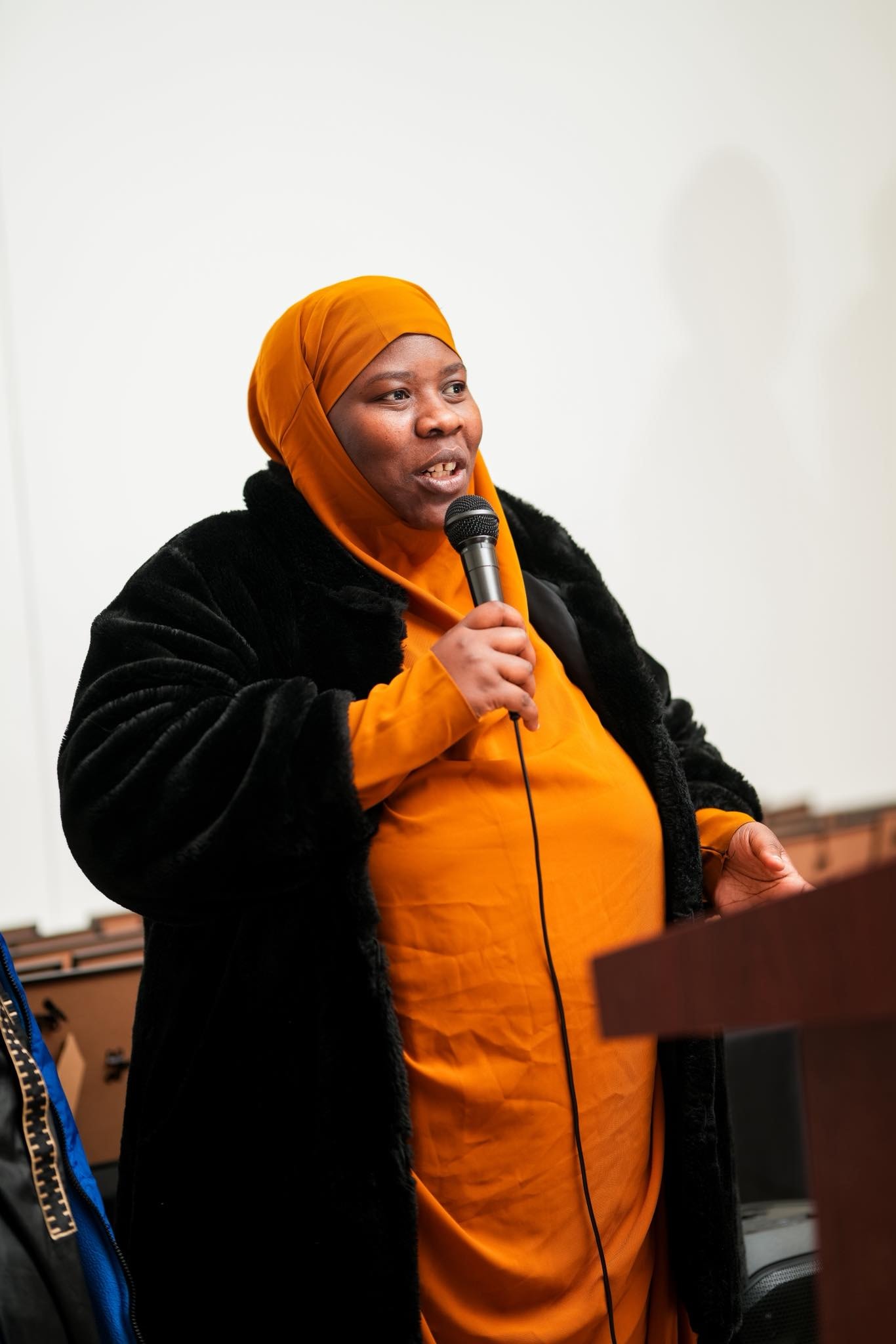Woman speaking into a microphone at an event