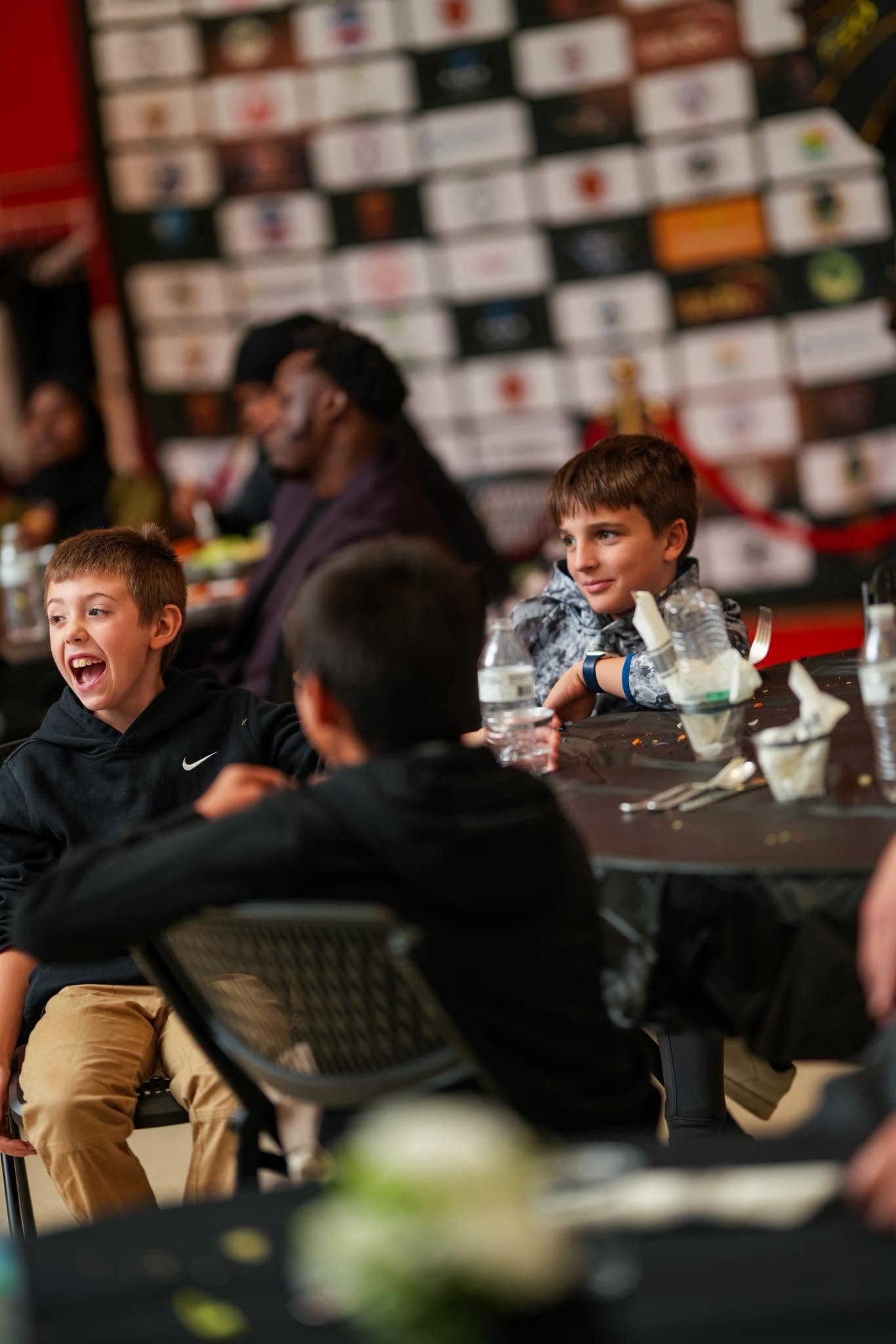 Children laughing together at a community event table