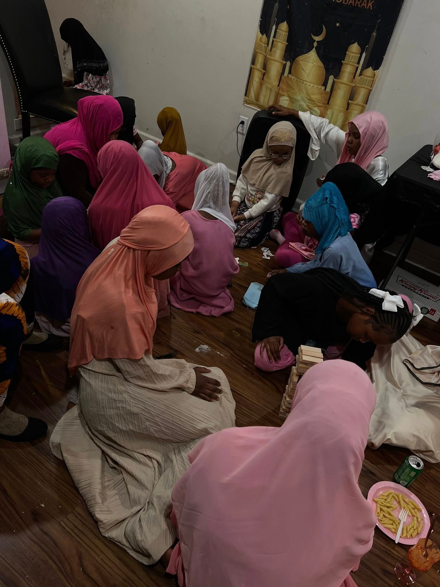 Women gathering indoors wearing colorful headscarves