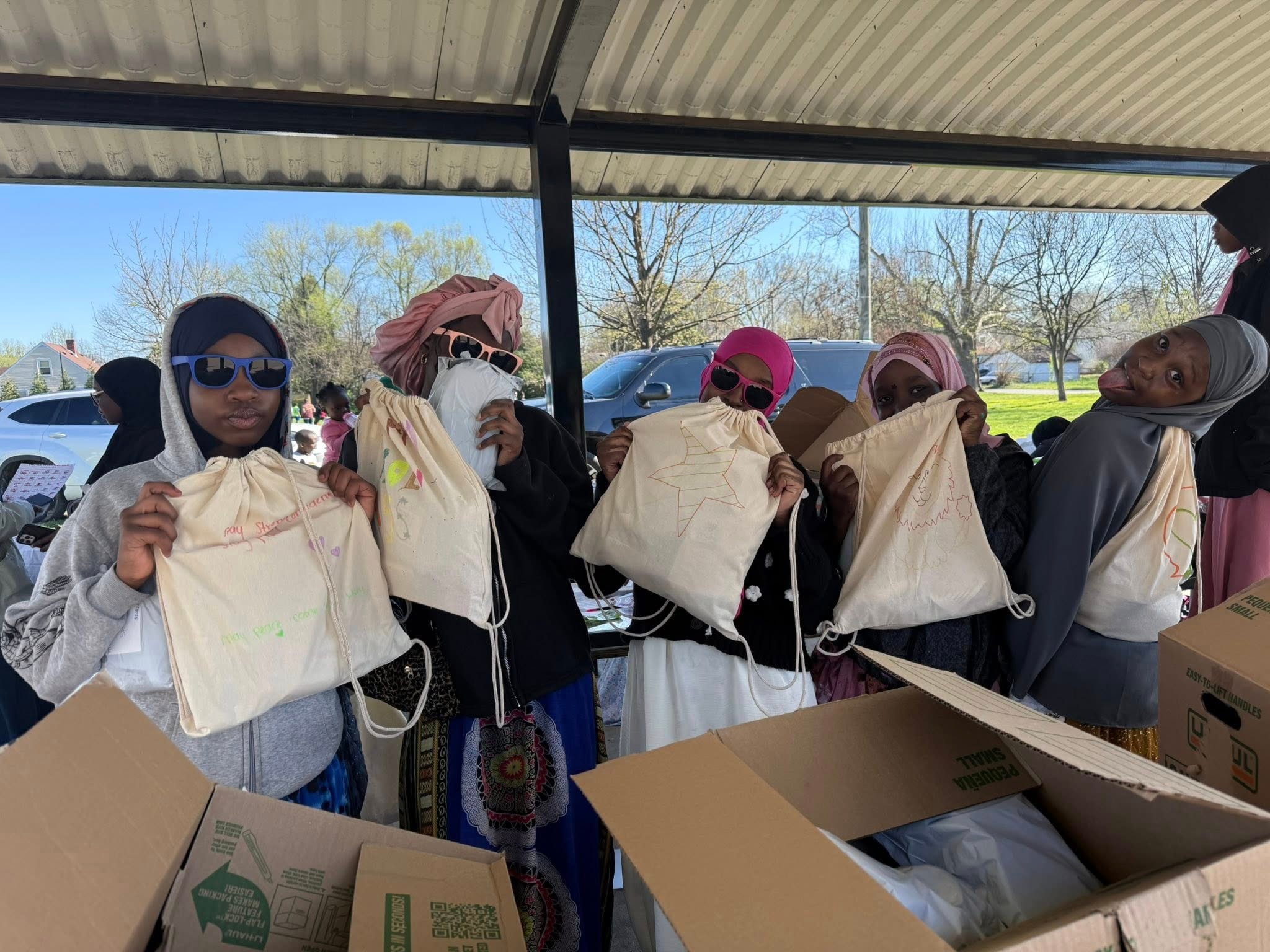 Group holding drawstring bags at a community event