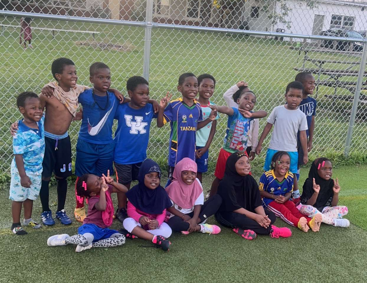 Group of children smiling at a sports field
