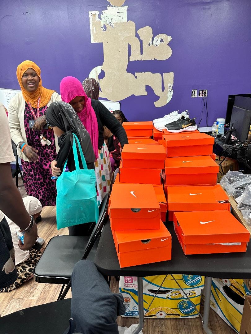 Women receiving donated Nike shoe boxes